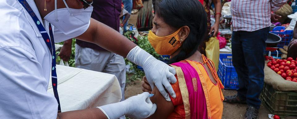 Une femme reçoit une injection d'un vaccin anti-Covid sur un marché à Hyderabad, en Inde, le 24 juin 2021. [AP/Keystone - Mahesh Kumar]