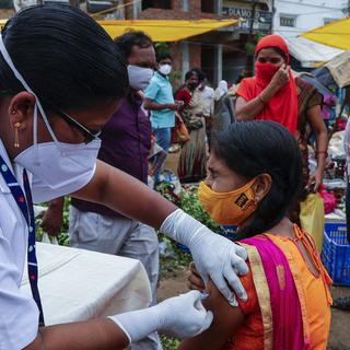 Une femme reçoit une injection d'un vaccin anti-Covid sur un marché à Hyderabad, en Inde, le 24 juin 2021. [AP/Keystone - Mahesh Kumar]