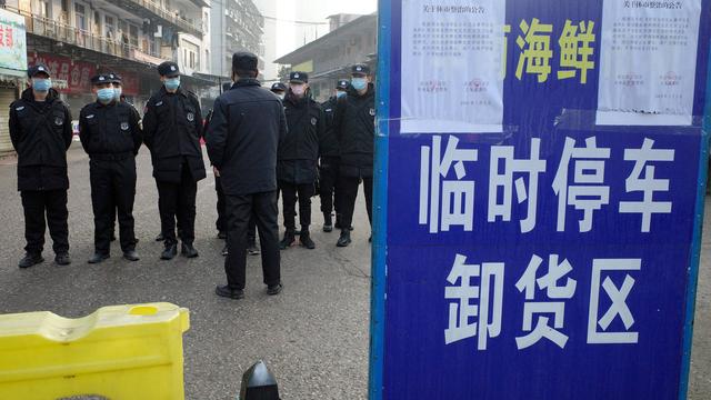 Image d'archives: des agents de sécurité devant un marché fermé de Wuhan, dont un homme de 61, le premier à mourir du virus du Covid-19, était un client régulier. [AFP - Noel Cells]