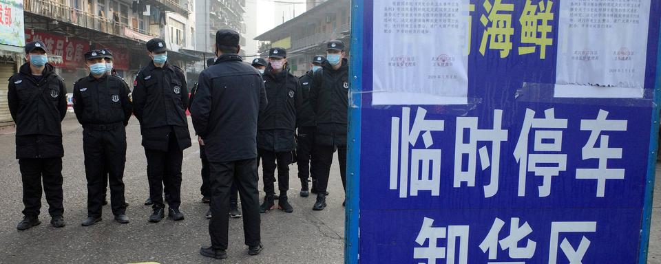 Image d'archives: des agents de sécurité devant un marché fermé de Wuhan, dont un homme de 61, le premier à mourir du virus du Covid-19, était un client régulier. [AFP - Noel Cells]