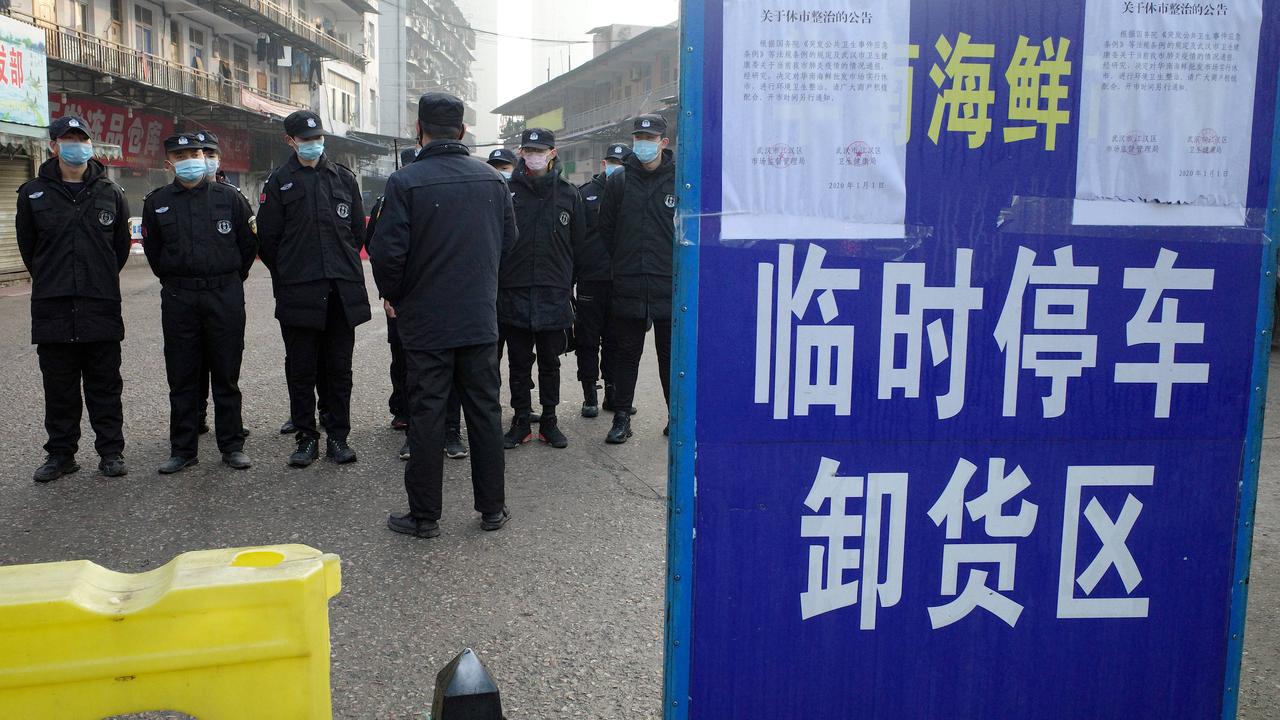Image d'archives: des agents de sécurité devant un marché fermé de Wuhan, dont un homme de 61, le premier à mourir du virus du Covid-19, était un client régulier. [AFP - Noel Cells]