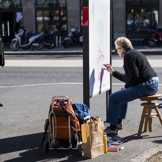 L'artiste Sylvie Mermoud réalise une oeuvre sur un emplacement publicitaire à l'initiative de la Ville de Lausanne le jeudi 25 mars 2021. [Keystone - Jean-Christophe Bott]