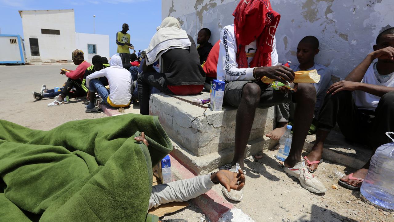 Des migrants attendent à Ben Gardane, dans le sud de la Libye. Les personnes migrantes sont régulièrement abusées et torturées dans les lieux de détention libyens. [AP/Keystone - Mehdi El Arem]