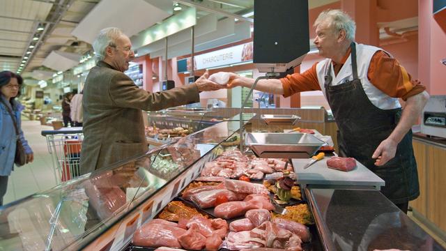 Un client choisit de la viande dans un rayon boucherie d'un centre commercial de Zurich. [Keystone - Alessandro Della Bella]