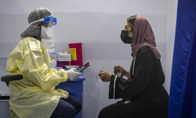 Une soignante marocaine scanne un code QR avant d'administrer une dose de vaccin anti-Covid à une patiente au vaccinodrome intelligent de Casablanca. [AFP - Fadel Senna]