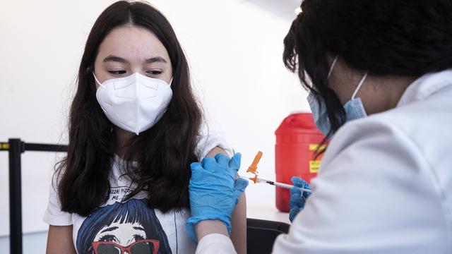 Une adolescente de 15 ans reçoit une infection du vaccin anti-Covid de la firme Pfizer, le 13 mai 2021. [EPA/Keystone - Etienne Laurent]