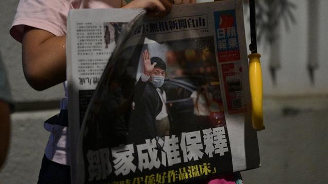 Un enfant tient l'édition du 23 juin 2021 du journal hongkongais Apple Daily. [AFP - Anthony Wallace]