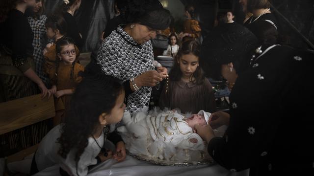 Des femmes juives ultra-orthodoxes ornent Yossef Tabersky, âgé de 30 jours, l'arrière-petit-fils du grand rabbin de la dynastie hassidique Lelov, pendant la cérémonie du "Pidyon Haben" à Beit Shemesh, en Israël, le jeudi 16 septembre 2021. [AP Photo/ Keystone - Oded Balilty]