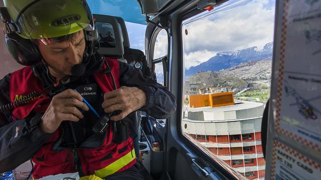 Un médecin se prépare à poser une blessée avec un hélicoptère dà l'hôpital de Sion (image d'illustration). [Keystone - Olivier Maire]