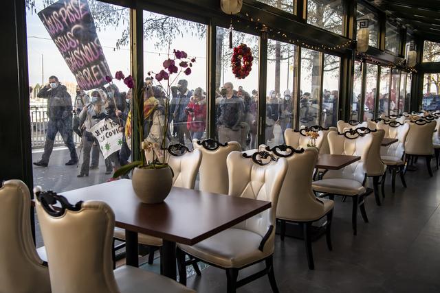 Les manifestants passent devant un restaurant fermé de Neuchâtel. [Keystone - Martial Trezzini]