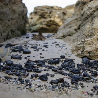 Des traces de la marée noire sur une plage israélienne. [Keystone/AP Photo - Ariel Schalit]