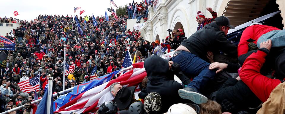 Des supporters de Donald Trump tentent d'entrer dans le Capitole. [Reuters - Shannon Stapleton]