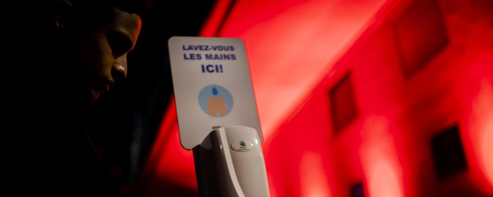 Un client lave ses mains avec du gel désinfectant devant la discothèque le D! Club, le jeudi 2 juillet 2020 à Lausanne. [KEYSTONE - JEAN-CHRISTOPHE BOTT]