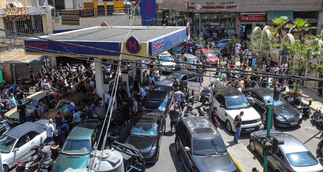 Les Libanais se pressent dans une station-service de Beyrouth pour faire le plein, le 14 août 2021, avant la future augmentation du prix du carburant. [Keystone - Nabil Mounzer]