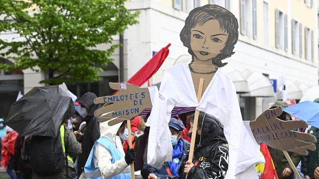 A Genève, un millier de personnes participent samedi sous la pluie au traditionnel défilé du 1er Mai. [KEYSTONE - MARTIAL TREZZINI]