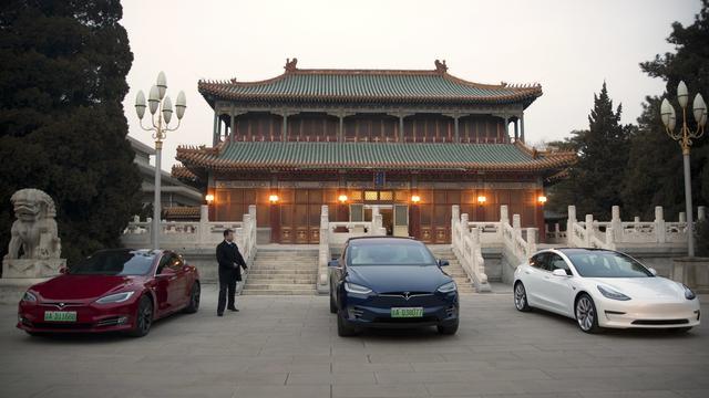 Des voitures Tesla devant un bâtiment à Pékin. [Keystone/AP Photo - Mark Schiefelbein]