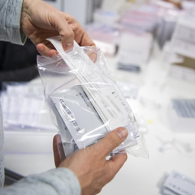 Un sachet contenant des autotests pour le dépistage du coronavirus. [Keystone - Jean-Christophe Bott]