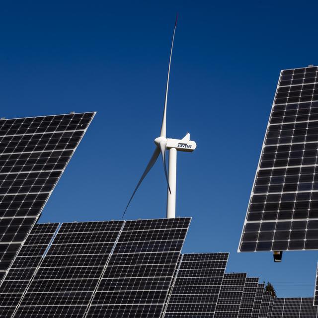 Une éolienne et des panneaux solaires au Mont-Soleil, dans le Jura bernois. [Keystone - Valentin Flauraud]