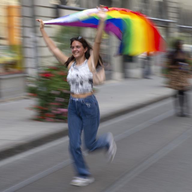 Une personne arbore le drapeau LGBT+ dans une rue de Genève, à l'occasion de la Marche des fiertés, le 11 septembre 2021. [Keystone - Salvatore Di Nolfi]