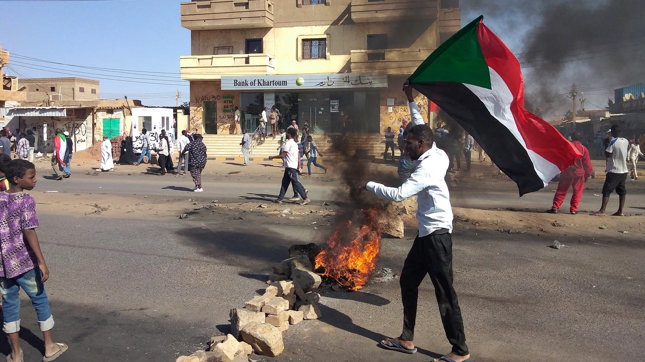 Des opposants soudanais au coup d'État militaire sont rassemblés derrière un barrage routier lors d'une manifestation dans la ville d'Omdurman, le 13 novembre 2021. [AFP]