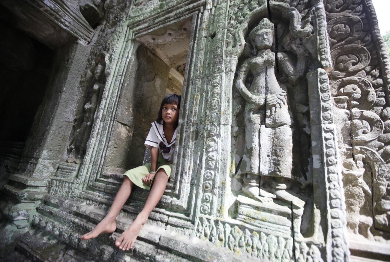 Une jeune fille dans le temple de Bayon, faisant partie de l'ensemble archéologique d'Angkor, au Cambodge. [Keystone/AP photo - Eugene Hoshiko]