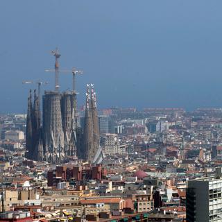 Vue générale de la ville de Barcelone avec l'église Sagrada Familia (L), à Barcelone, en Espagne, le 01 juillet 2019. Le gouvernement régional de Catalogne a déclaré un épisode de pollution atmosphérique dû aux particules (PM10) et une alerte précoce de pollution atmosphérique au dioxyde d'azote. [EPA/Keystone - Quique Garcia]