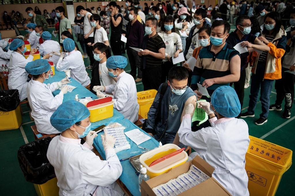 Des universitaires attendent pour recevoir le vaccin contre la Covid-19 de China National Biotec Group (CNBG), à Wuhan. Chine, le 28 avril 2021. [AFP - STR]