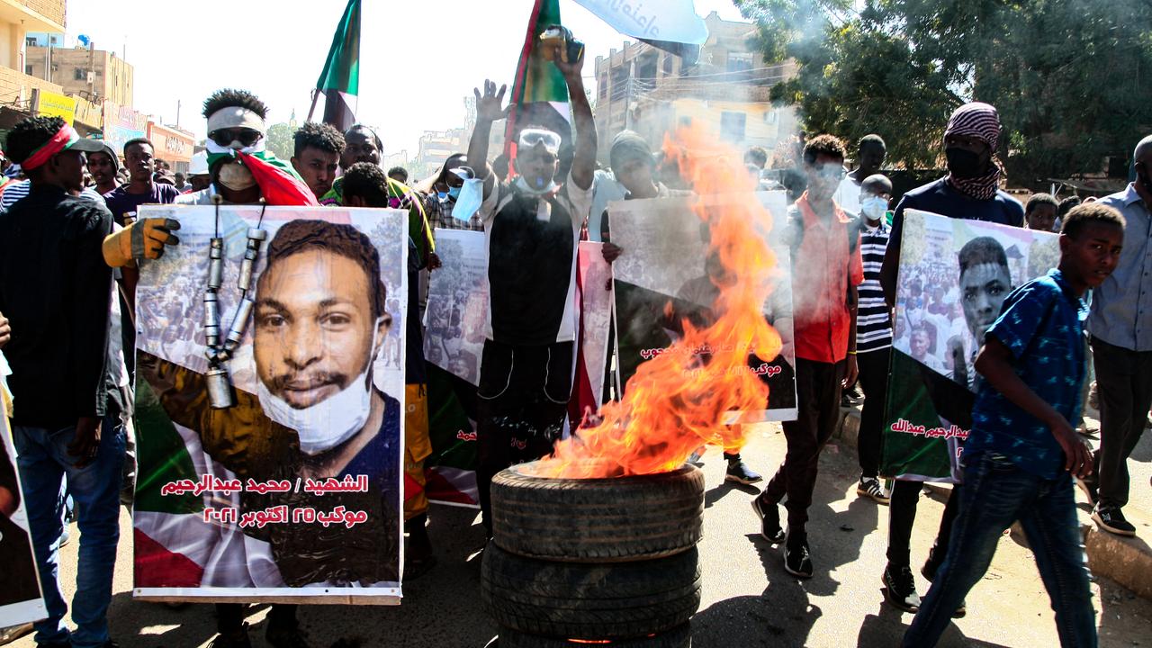 Des Soudanais portent des affiches de protestataires tués lors d'une manifestation dans la capitale Khartoum contre le coup d'État de l'armée du 25 octobre, le 30 décembre 2021. [AFP]