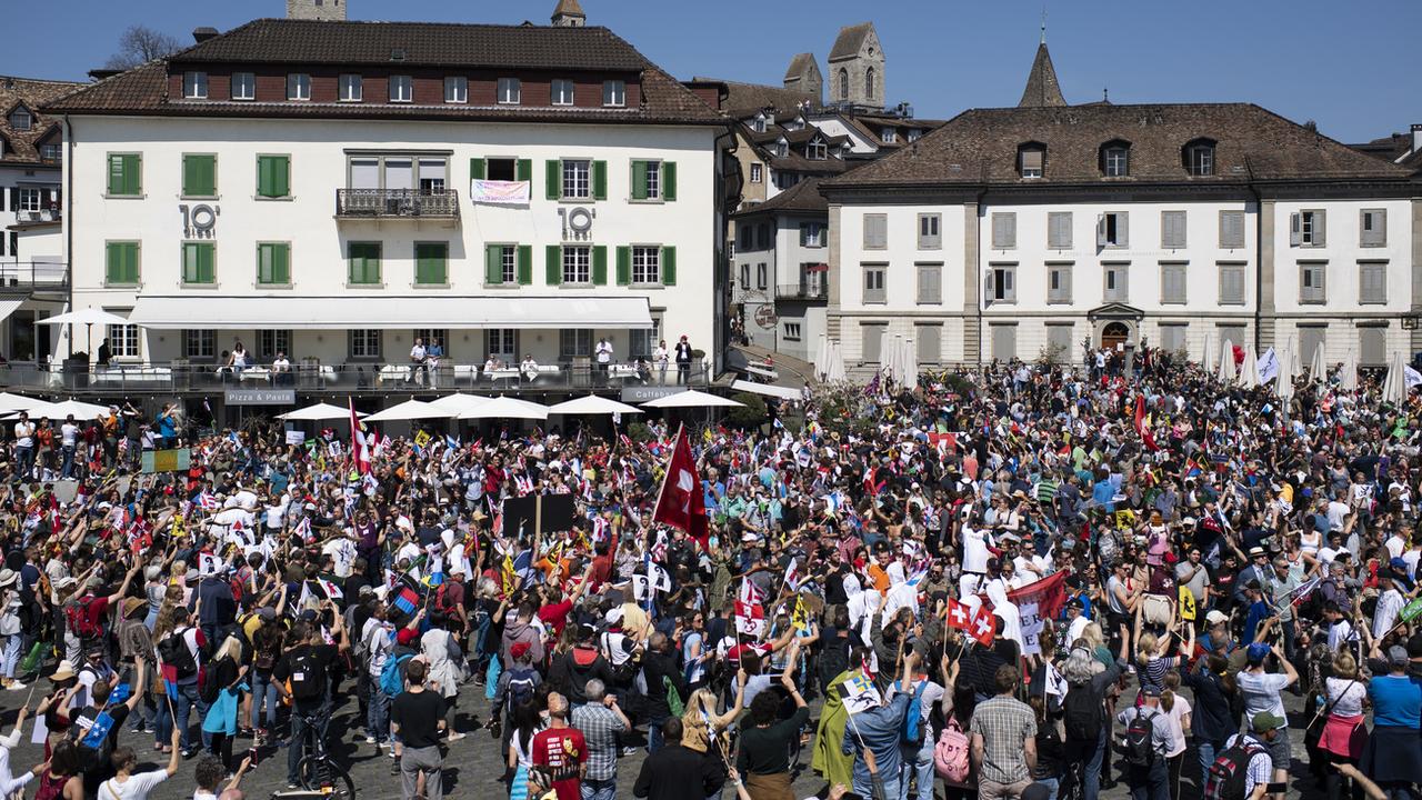 Une manifestation interdite contre les mesures anti-coronavirus a réuni plusieurs milliers de personnes non masquées samedi à Rapperswil-Jona. [Keystone - Gian Ehrenzeller]