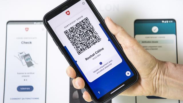 Un visuel présentant l'aspect du nouveau certificat Covid sur un smartphone. [Keystone - Jean-Christophe Bott]