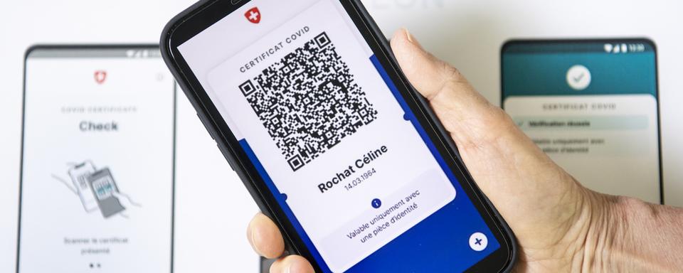 Un visuel présentant l'aspect du nouveau certificat Covid sur un smartphone. [Keystone - Jean-Christophe Bott]