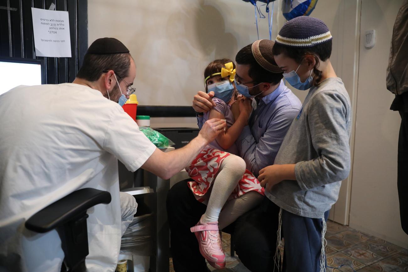 Une fillette reçoit une injection du vaccin contre le Covid-19, le 23 novembre 2021 à Jérusalem. [EPA/Keystone - Abir Sultan]