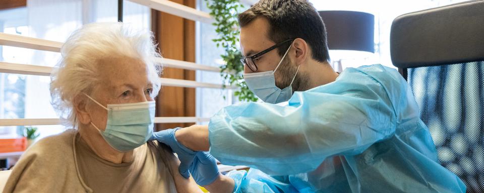 Une patiente d'un EMS vaudois reçoit une dose de vaccin contre le Covid. Image d'illustration prise en janvier 2021. [Keystone - Cyril Zingaro]