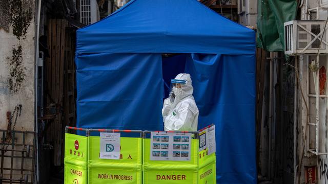 Une personne mobilisée devant une sanitaire dans un quartier confiné de Hong Kong, le 23 janvier 2021. [EPA/Keystone - Jérôme Favre]