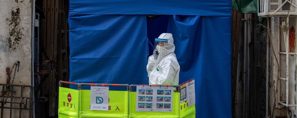 Une personne mobilisée devant une sanitaire dans un quartier confiné de Hong Kong, le 23 janvier 2021. [EPA/Keystone - Jérôme Favre]