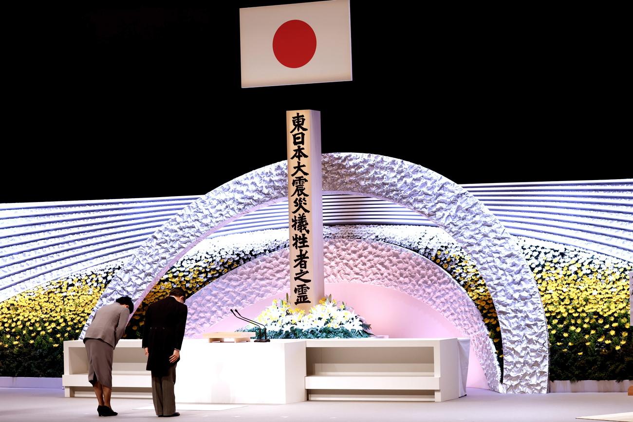 Naruhito, empereur du Japon, et son épouse l'impératrice Masako, s'inclinent devant l'autel dressé en mémoire des victimes du séisme et du tsunami du 11 mars 2011. Tokyo, le 11 mars 2021. [Keystone/epa - Behrouz Mehri/Pool]
