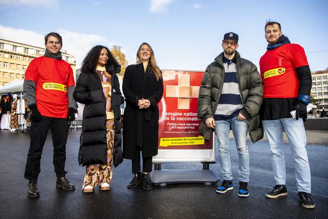 Les chanteuses Danitsa et Sophie Hunger, ainsi que le chanteur Stress posent avec des personnes de l'équipe de vaccination à Lausanne. [Keystone - Jean-Christophe Bott]