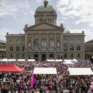 Vue de la place fédéral de Berne remplie de manifestantes, avec le Parlement en fond. [KEYSTONE - Peter Klaunzer]