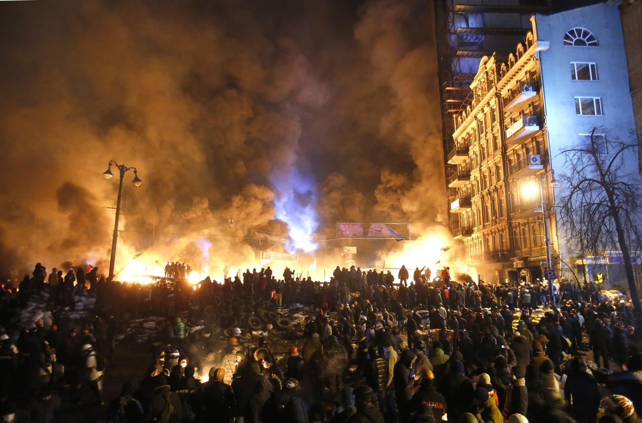 Des milliers de manifestants massés sur la place Maidan à Kiev, où des affrontements ont lieu avec l'armée. [AP/Keystone - Sergei Grits]