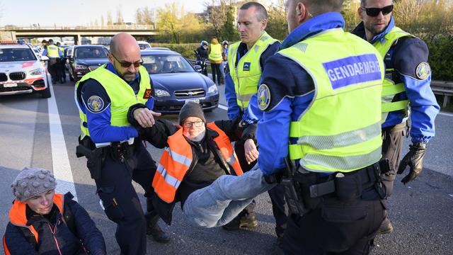 Des policiers évacuent des activistes du climat qui ont bloqué l'autoroute au sud de Lausanne. [Keystone - Laurent Gillieron]