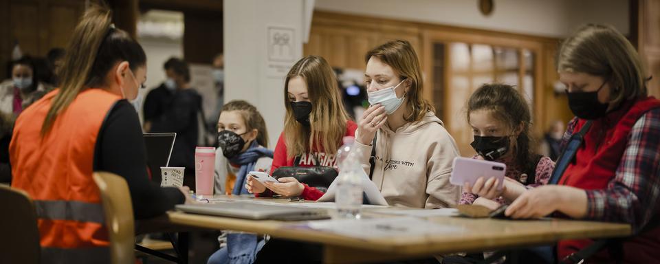 Une famille d'Ukraine pendant la procédure d'enregistrement dans un centre d'accueil pour réfugiés à Zurich, le 15 mars 2022. [Keystone - Michael Buholzer]