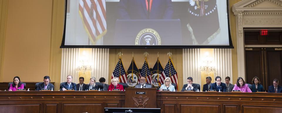 L'ancien président américain Donald Trump est projeté sur un écran au-dessus de la commission d'enquête sur l'assaut du 6 janvier 2021 sur le Capitole. [KEYSTONE - Jim Lo Scalzo / EPA]