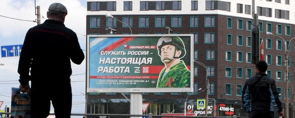 Un panneau d'affichage à Saint-Pétersbourg promeut le service militaire contractuel avec l'image d'un militaire et le slogan "Servir la Russie est un vrai travail". [AFP - Olga Maltseva]