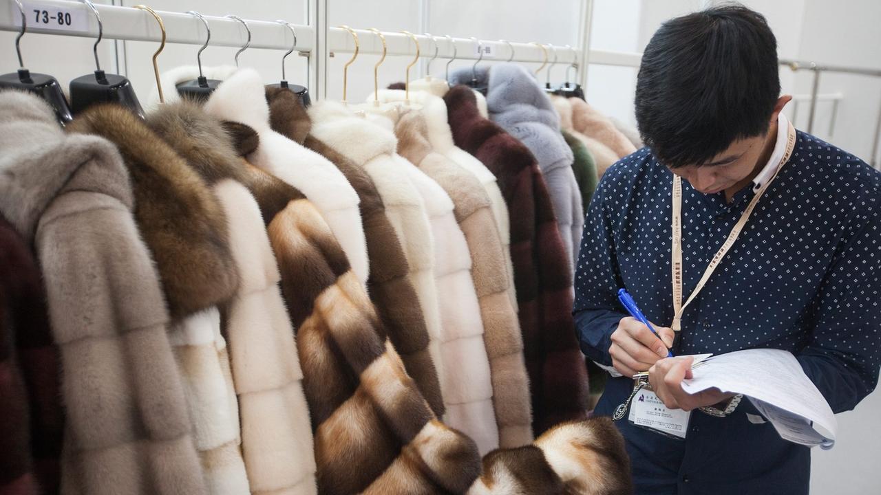 Un commerçant prend des notes lors du Salon international de la fourrure et de la mode de Hong Kong, en Chine, le 25 février 2015. [Keystone - EPA/ALEX HOFFORD]