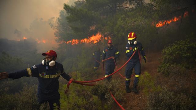 Des pompiers luttent pour éteindre un feu de forêt près de la station balnéaire de Vatera, sur l'île de Lesvos, dans la mer Égée orientale, en Grèce, samedi 23 juillet 2022. [AP Photo/KEYSTONE - Panagiotis Balaskas]