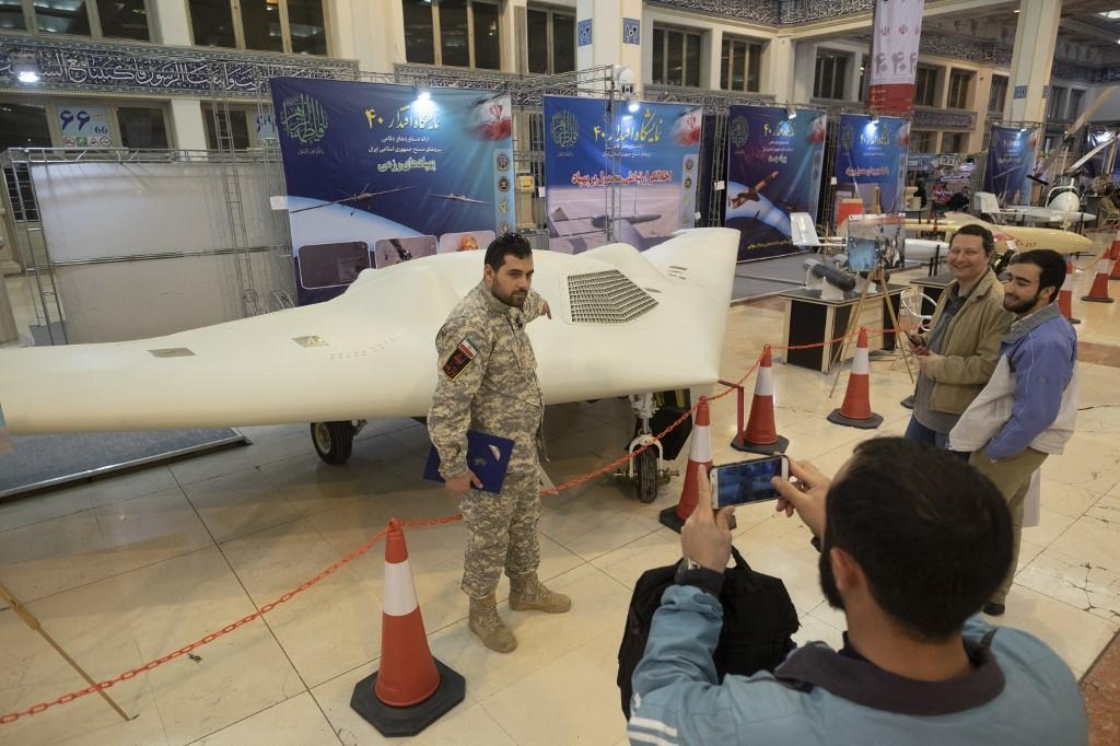 Un membre du Corps des gardiens de la révolution islamique pose devant un drone Shahed-171, lors du jubilé des 40 ans de la révolution, à Téhéran, en février 2019. [AFP - Morteza Nikoubazl/NurPhoto]