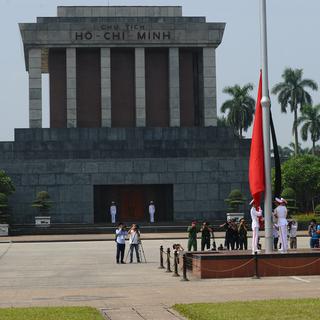 Des soldats élèvent le drapeau vietnamien devant le mausolée de Ho Chi Minh à Hanoi. [AFP/Keystone - Hoang Dinh Nam]