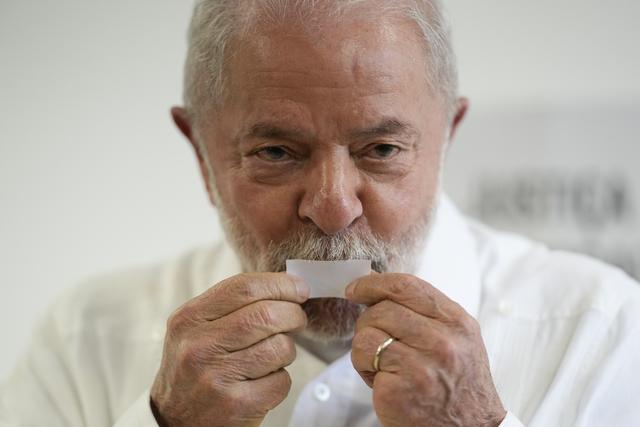 L'ex-président Lula pose un baiser sur son ticket après avoir voté pour le second tour de la présidentielle brésilienne. [AP/Keystone - Andre Penner]