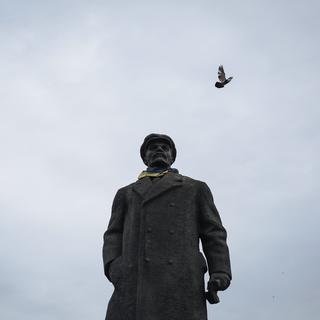 La statue de l'ancien dirigeant soviétique Vladimir Lénine habillé avec un drapeau national ukrainien autour du cou se trouve devant le bâtiment de l'administration régionale dans la ville de Slaviansk, dans l'est de l'Ukraine, le 12 mars 2015. [EPA/KEYSTONE - Roman Pilipey]