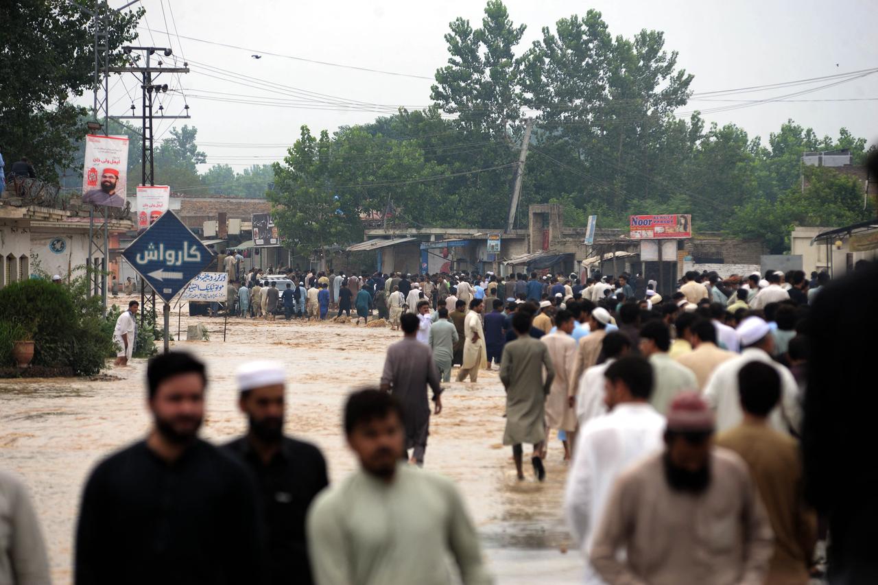 La population pataugent dans l'eau après une crue soudaine qui a frappé le district de Charsadda, dans le nord-ouest de la province de Khyber Pakhtunkhwa. [AFP - Zubair Abbasi]